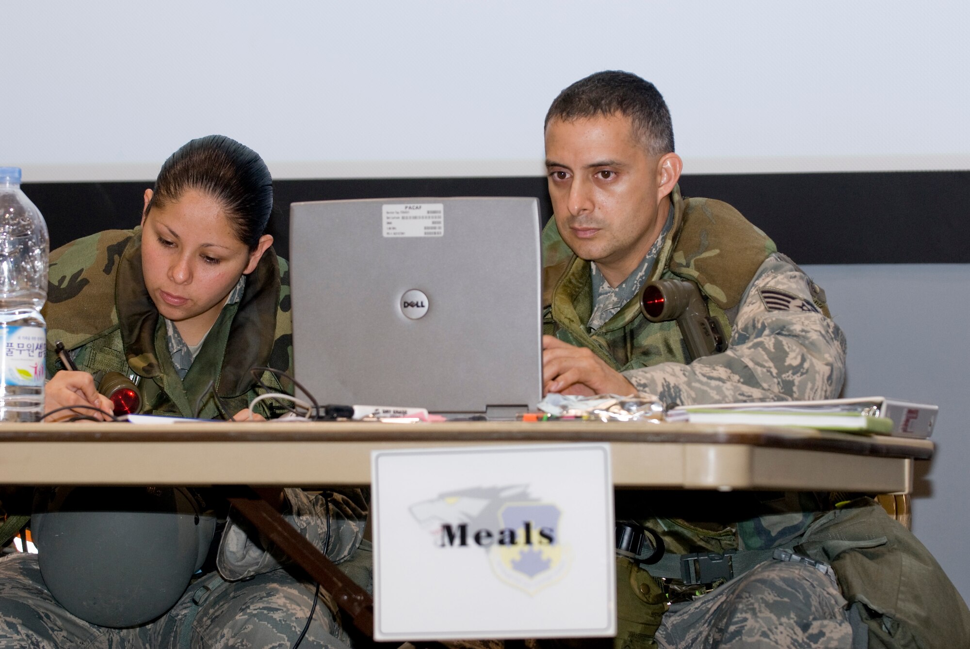 KUNSAN AIR BASE, Republic of Korea -- Senior Airman Brianna Flores and Staff Sgt. Eziquiel Ortiz review the final details of a plan for follow on forces arriving during a week-long exercise here July 20, 2009. Airman Flores and Sergeant Ortiz are from the 8th Force Support Squadron and are responsible for in-processing follow on forces. Throughout the week, Wolf Pack Airmen, Soldiers and civilians will showcase their ability to survive and operate in simulated wartime contingencies by demonstrating how they defend the base, accept follow-on forces and take the fight north during an Operational Readiness Exercise. (U.S. Air Force photo by Senior Airman Jonathan Steffen)