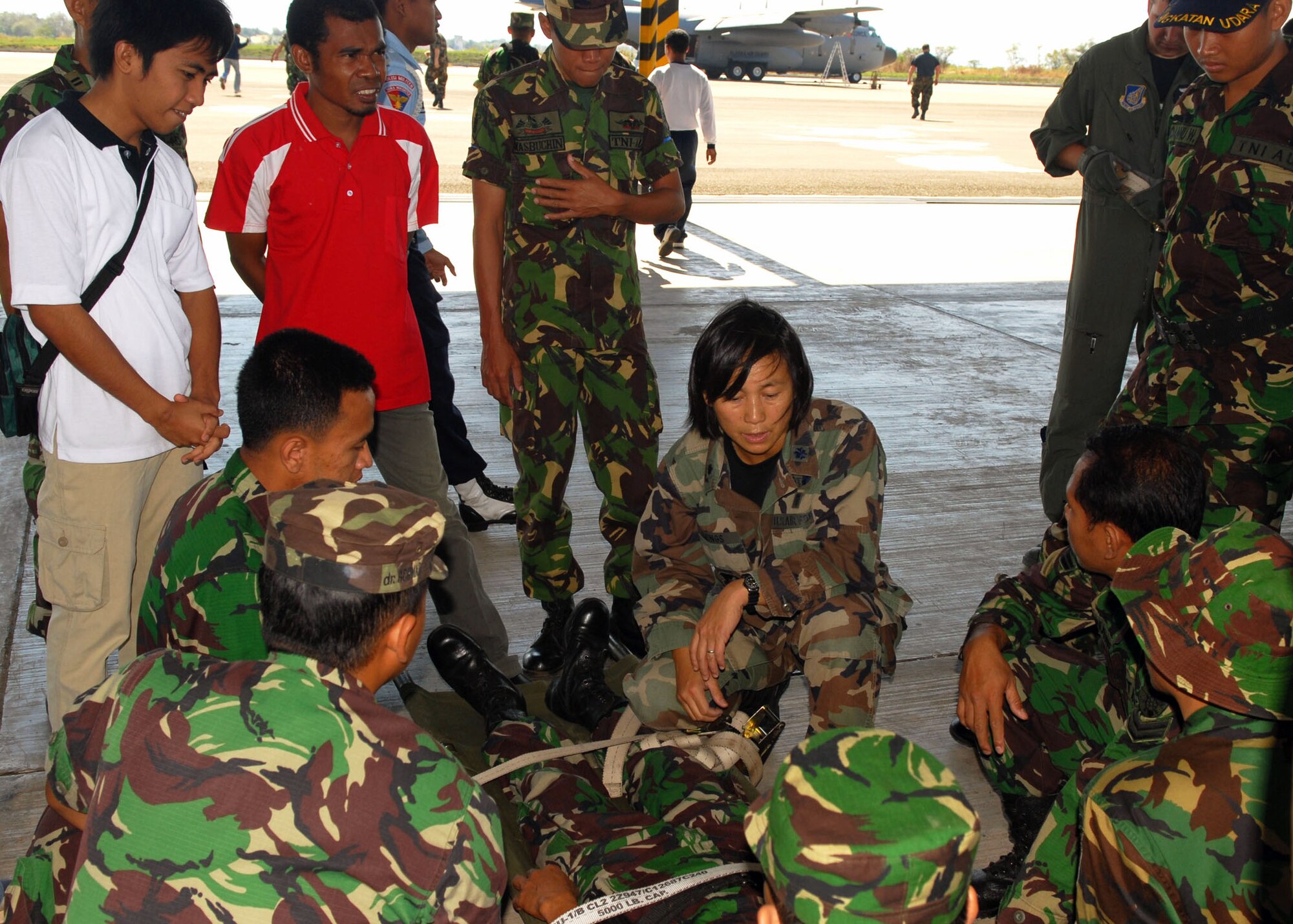 Lt. Col. Peerach Ewings, an international health specialist assigned to the 13th Air Force at Hickam Air Force Base, Hawaii, goes over litter transport techniques July 19 at El Tari Air Force Base, Indonesia.  U.S. Airmen in Indonesia as part of Operation Pacific Angel 2009 practiced loading patients with the Indonesian military and local doctors. Pacific Angel is a Pacific Air Forces humanitarian and civic assistance program conducted in the Asia-Pacific region and led by 13th Air Force at Hickam Air Force Base, Hawaii. (U.S. Air Force photo/Senior Master Sgt. Russell Dodson)