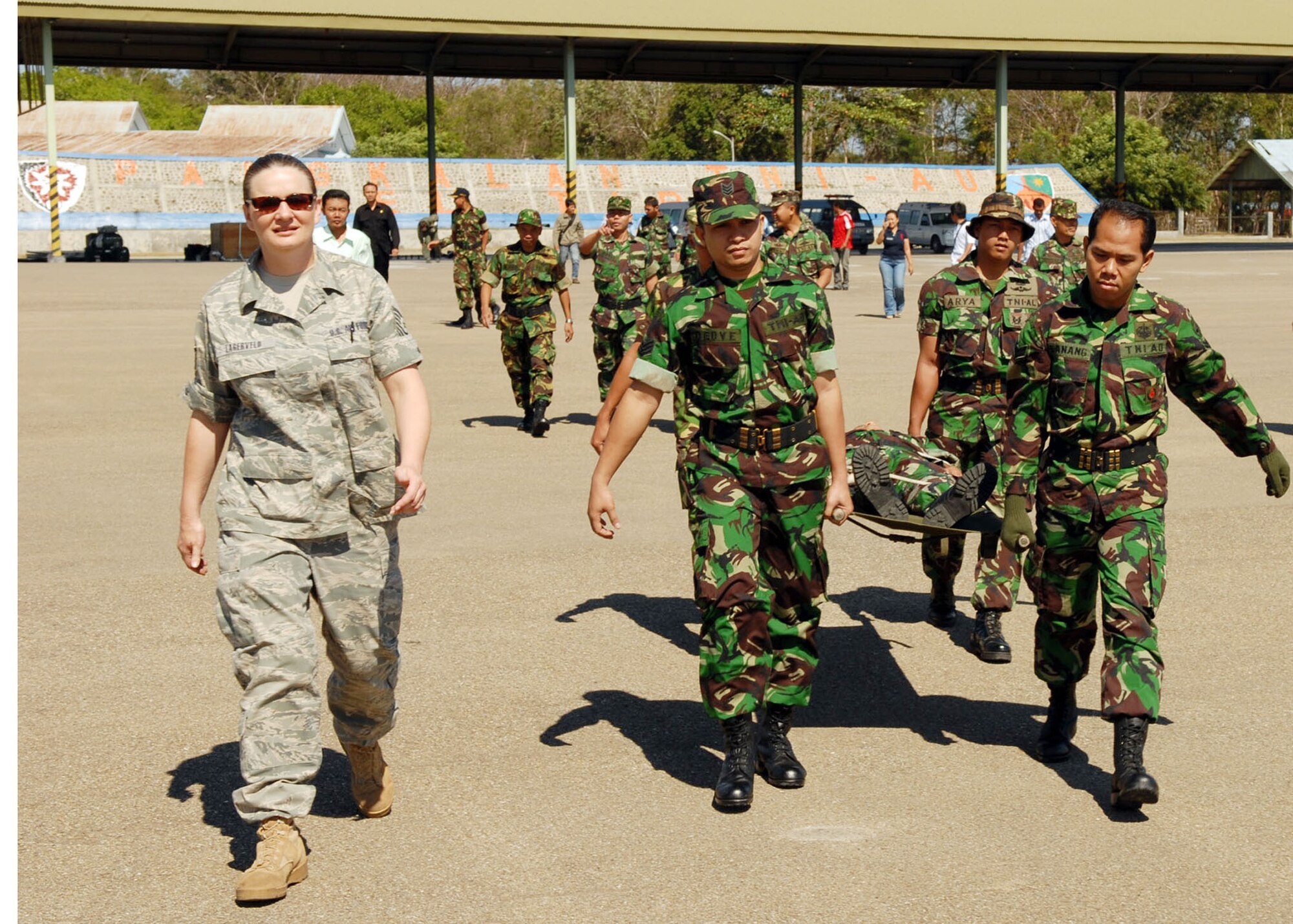 Tech. Sgt. Jessica Lagerveld, an independent duty medical technician from Kadena Air Base, Japan, escorts Indonesian military and medical professionals to an Air National Guard C-130 Hercules July 19 at El Tari Air Force Base, Indonesia.  Sergeant Lagerveld is in Indonesia as part of Operation Pacific Angel 2009, a Pacific Air Forces humanitarian and civic assistance program conducted in the Asia-Pacific region and led by 13th Air Force at Hickam Air Force Base, Hawaii. (U.S. Air Force photo/Senior Master Sgt. Russell Dodson)