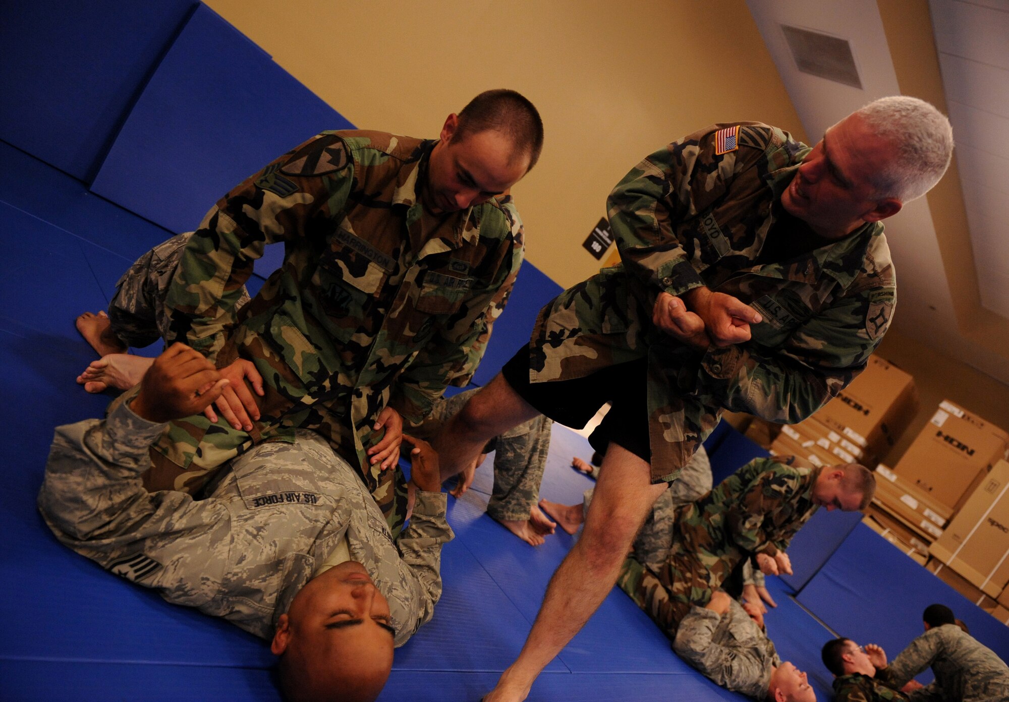 CAMP BLANDING, Fla. -- Sgt. 1st Class Donald Boyd, 211th Regiment, Regional Training Institute instructs Senior Airman Joel Harrington, battlefield weather forecaster from the 3rd Weather Squadron at Fort Hood, Texas, and Staff Sgt. Javier Acosta, a battlefield weather forecaster from Detachment 2, 7th Weather Squadron at Grafenwoehr, Germany, on proper techniques for combatives during combat weather training at here July 17. (U.S. Air Force photo by Senior Airman Gina Chiaverotti-Paige)