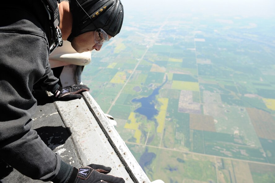 MINOT AIR FORCE BASE, N.D. -- Sgt. Ryan Bonham, a member of the United States Army Parachute Team the Golden Knights, peers over the edge of the aircraft to spot the ground target prior to his jump during the open house here July 18, 2009. The Golden Knights conduct parachute demonstrations, tandem jumps and compete in national and international competitions in support of the U.S. Army Accessions Command's tactical, operational, and strategic missions; creating a greater propensity to serve in the U.S. Army, while connecting America with America's Army. (U.S. Air Force photo by Tech. Sgt. Linda C. Miller)