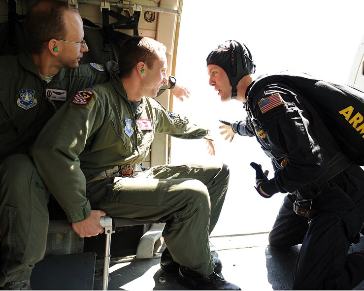 MINOT AIR FORCE BASE, N.D. -- Sgt. Daniel Cook, a member of the United States Army Parachute Team the Golden Knights, has Captains Philip Blong (center) and Adrian Zollinger (Left), members of the 91st Missile Wing Operations Support Squadron, stick their hands outside the aircraft to show how the wind pressure affects the bodies of the parachutists as they freefall during the open house here July 18, 2009. The Golden Knights conduct parachute demonstrations, tandem jumps and compete in national and international competitions in support of the U.S. Army Accessions Command's tactical, operational, and strategic missions; creating a greater propensity to serve in the U.S. Army, while connecting America with America's Army. (U.S. Air Force photo by Tech. Sgt. Linda C. Miller)
