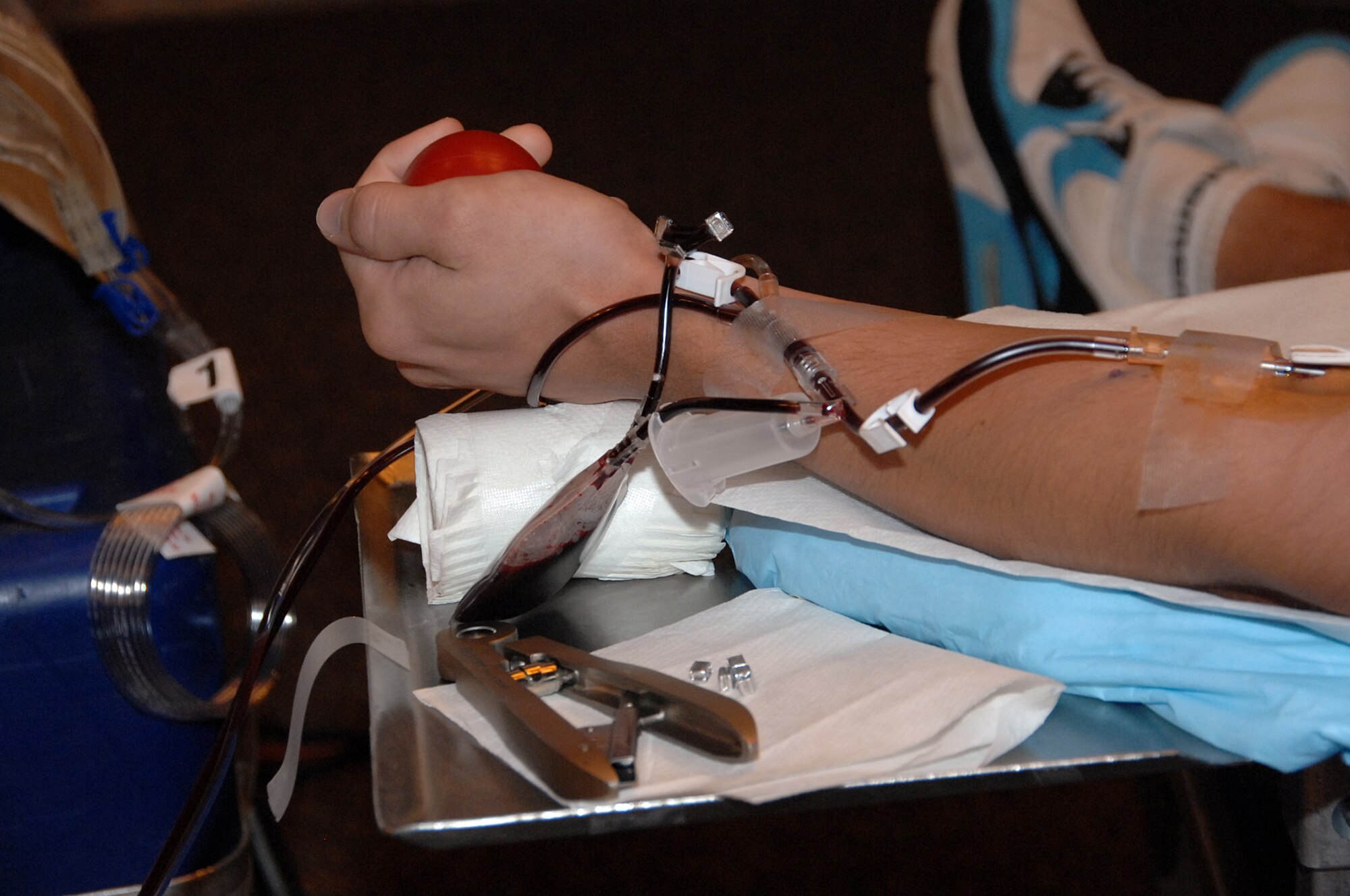 OFFUTT AIR FORCE BASE, Neb. -- A member of Team Offutt squeezes a ball as blood is drawn from his arm during a blood drive at the Community Center here July 16. Squeezing a ball during the donation process helps promote the flow of blood. U.S. Air Force Photo by Kendra Williams