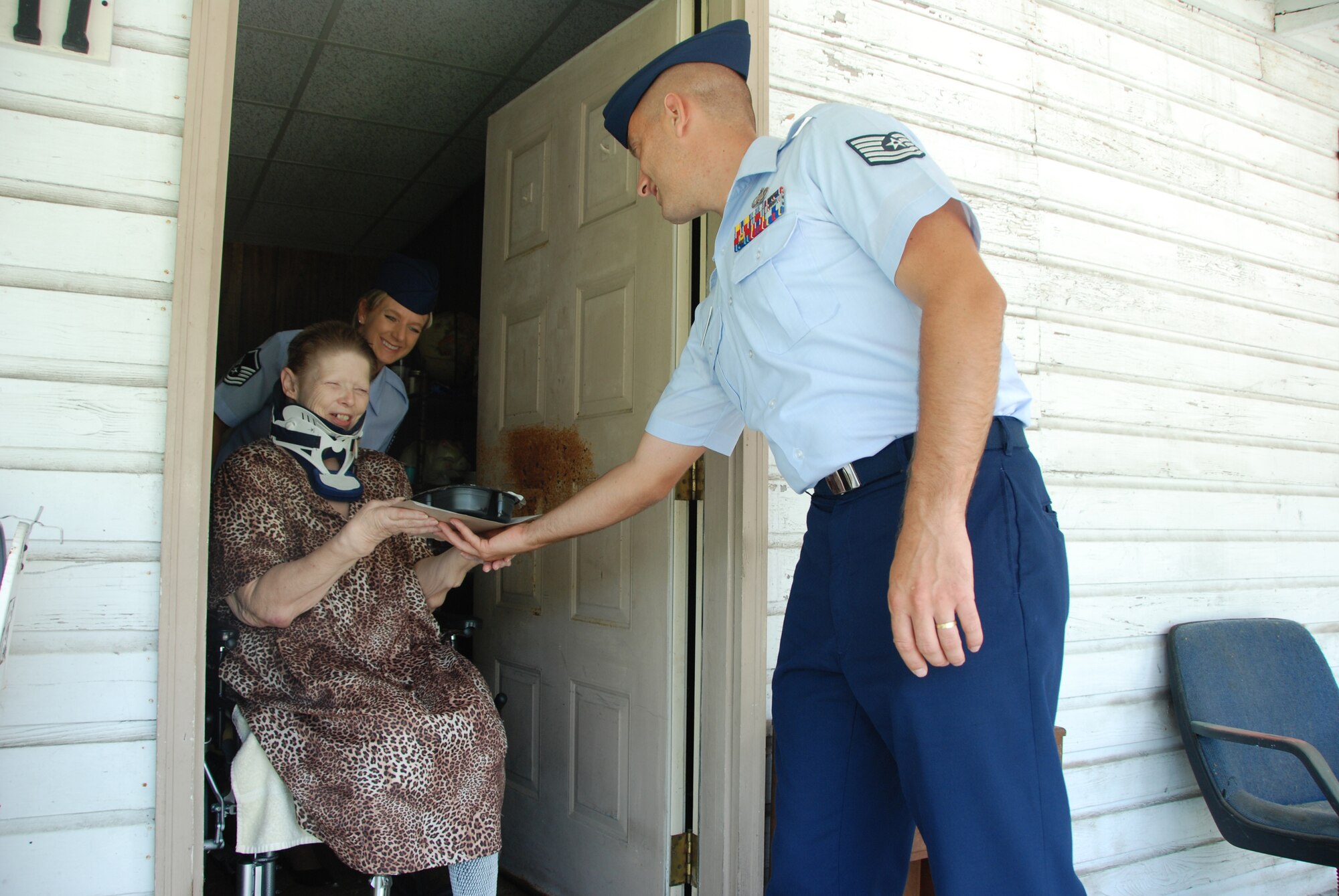 Master Sgt. Wendy Gehri and Tech. Sgt. Joe Ezell, members of America's AOC, deliver food to Ms. Lynda Cozad as a part of the Bay County Council on Aging Meals on Wheels program. (US Air Force Photo by: 1st Lt. Jared Scott)
