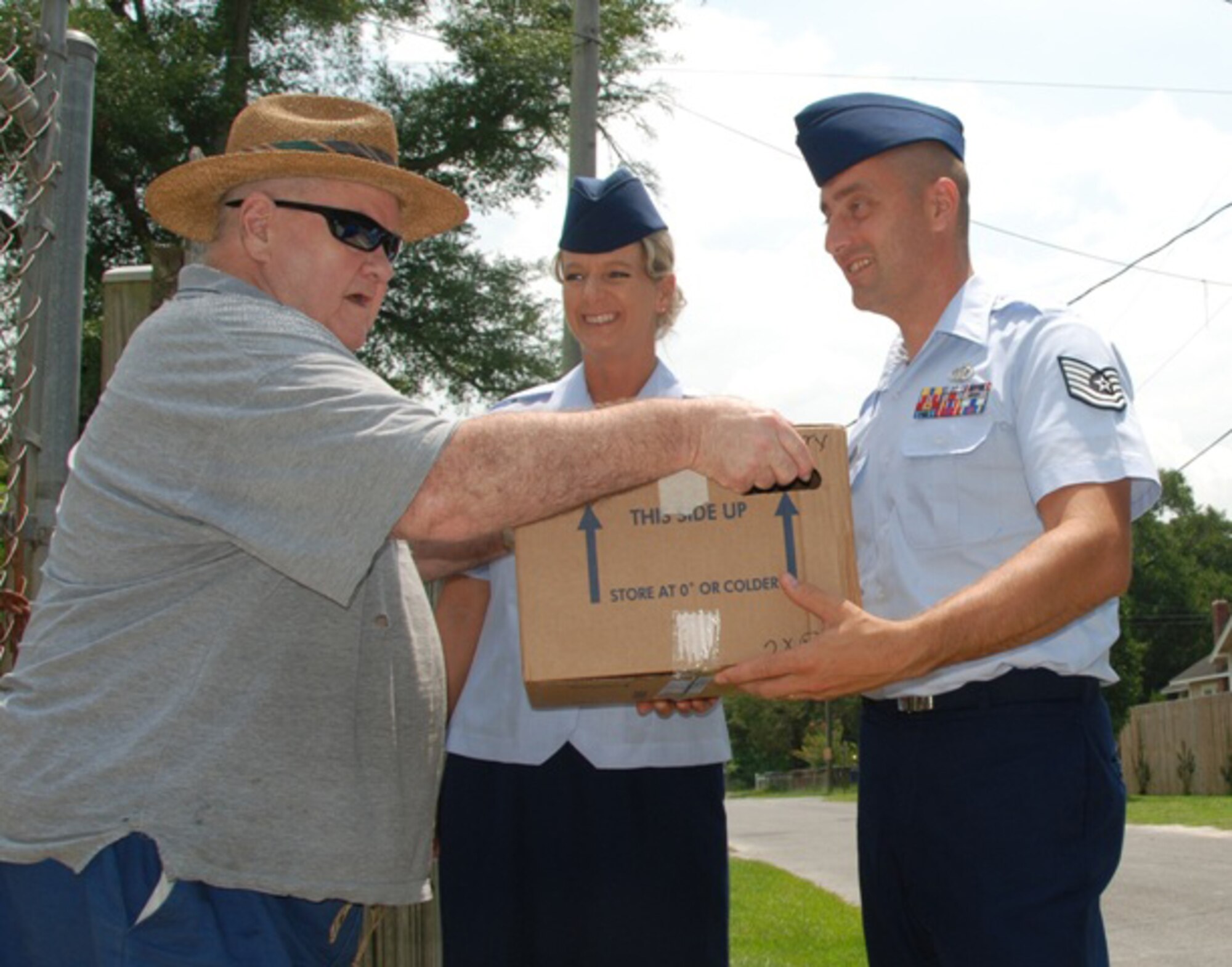 Master Sgt. Wendy Gehri and Tech. Sgt. Joe Ezell, members of the 601st Air and Space Operations Center, deliver meals to Mr. Edwin Terry as part of the Bay County Council on Aging Meals on Wheels program. (US Air Force Photo by: 1st Lt. Jared Scott)