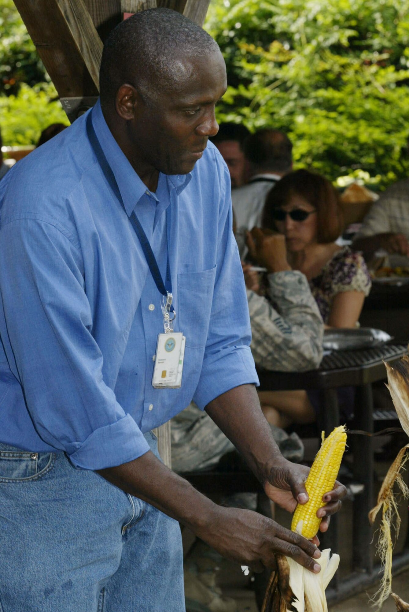 Bernard Parkinson of the 94th Communications Flight shucks an ear of corn during the annual Corn and Sausage Roast held at Dobbins Base Lakeside July 15. The event featured grilled sausages, grilled corn and a mini car show. The annual fund raising event is held in support of Family Emergency Services, which provides aide to employees during emergencies. (U.S. Air Force photo/Don Peek)