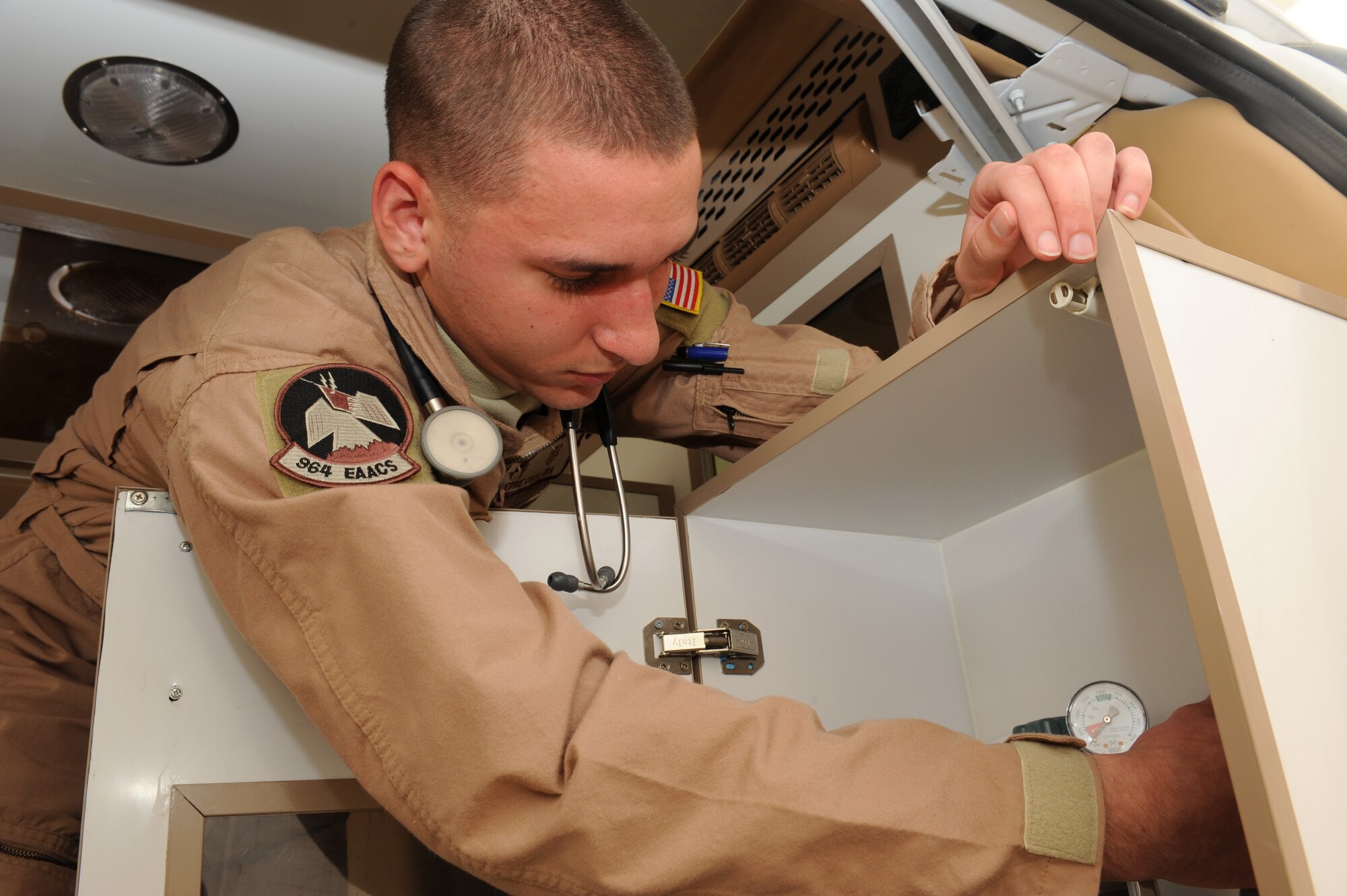 SOUTHWEST ASIA - Senior Airman Eddie Cuza, 964th Expeditionary Airborne Air Control Squadron, inspects an ambulance oxygen bottle as part of his routine equipment checks July 17. Airman Cuza is working as one of two Squadron Medical Element members while deployed out of Tinker Air Force Base, Okla., and hails from Edison, N.J. (U.S. Air Force photo Tech. Sgt. Charles Larkin Sr)