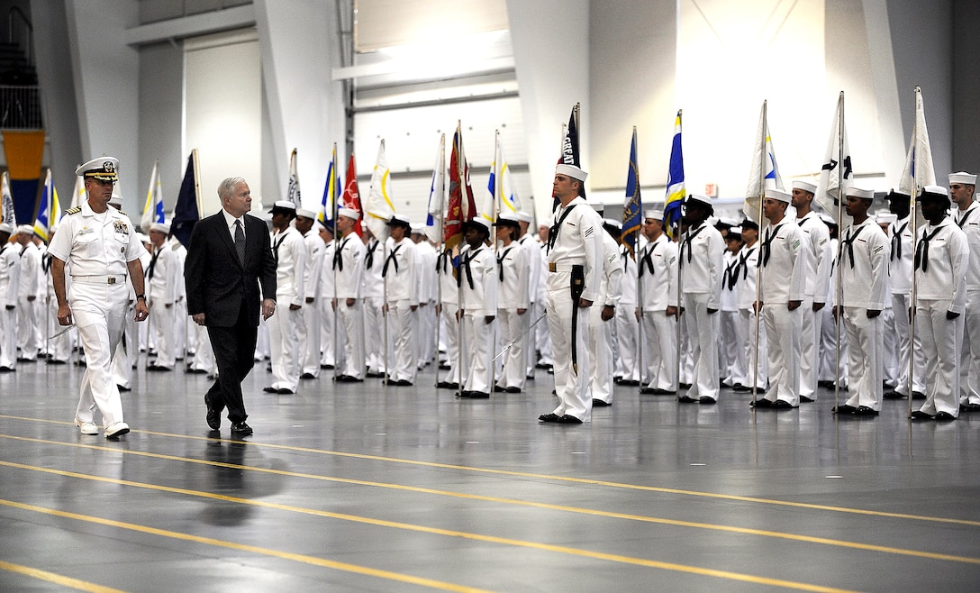 Navy Capt. John Peterson, commander of Recruit Training Command, left, and Defense Secretary Robert M. Gates perform a pass and review on Navy bootcamp graduates at Great Lakes Naval Training Center, Ill., July 17, 2009.
