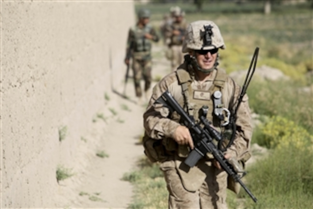 U.S. Marine Corps Capt. Jason Condon, a battalion air officer with 1st Battalion, 5th Marine Regiment, conducts a Civil Affairs Group patrol with Afghan soldiers in the Nawa District of Helmand province, Afghanistan, on July 17, 2009.  The Marines with 1st Battalion, 5th Marine Regiment, Regimental Combat Team 3, 2nd Marine Expeditionary Brigade - Afghanistan are deployed in support of NATO's International Security Assistance Force and will participate in counter insurgency operations and training and the mentoring of Afghan security forces.  