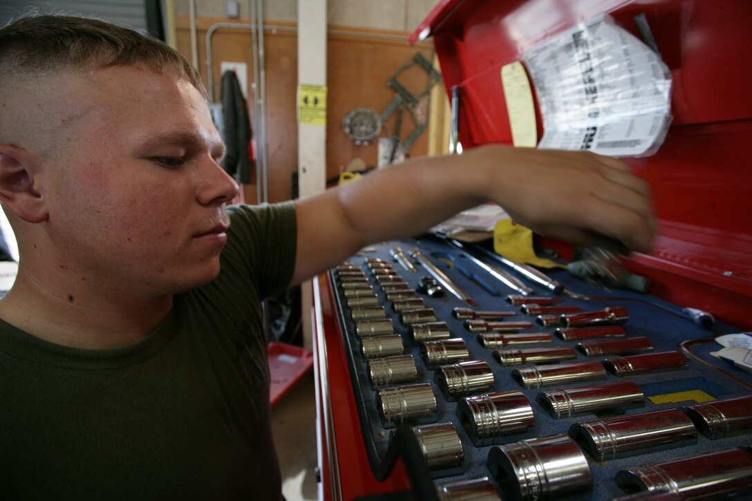 Lance Cpl. Paul Gordon, a motor transport mechanic with Exercise Support Division, searches for a tool while fixing a humvee at his unit July 21. Gordon said he enjoys working on cars and trucks in his spare time so fixing things as a Marine is a bonus.