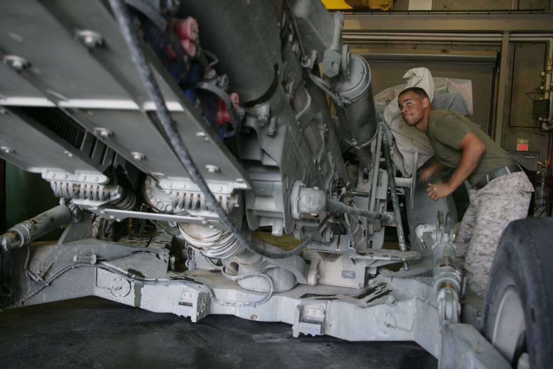 Lance Cpl. Sam Engebose, an artillery repair mechanic with Exercise Support Division, raises the barrel of an M777A2 howitzer July 21 after spending a week repairing the weapon.  ESD helps keep the thousands of Marines going through Enhanced Mojave Viper each year equipped with tactical vehicles, ordnance equipment and other gear.