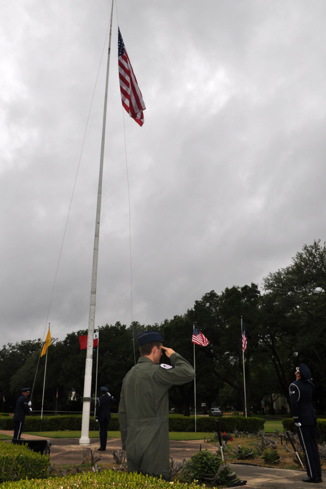 Members of the Barksdale Air Force Base Honor Guard place the flag at half mast to begin the RAIDR 21 Remembrance Ceremony in front of the 2nd Bomb Wing Headquarters building at Barksdale AFB, La., July 21, 2009. Family, friends and more than 200 Airmen were in attendance at the ceremony that remembered the six aircrew members who were lost a year ago off the coast of Guam. (U.S. Air Force photo/Tech. Sgt. Jeff Walston)