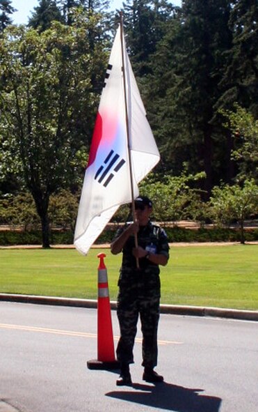 A member of the Republic of Korea team cheers on participants in the fit-to-fight competition for Air Mobility Command's RODEO 2009 July 19 at McChord Air Force Base, Wash.  More than 100 teams are participating in RODEO competition, including teams from seven foreign countries. RODEO is the U.S. Air Force's and AMC's premier air mobility competition. It's an international combat skills and flying operations competition designed to develop and improve techniques, procedures and interoperability with international partners to optimize mobility partnerships and enhance mobility operations. (U.S. Air Force Photo/Tech. Sgt. Scott T. Sturkol)