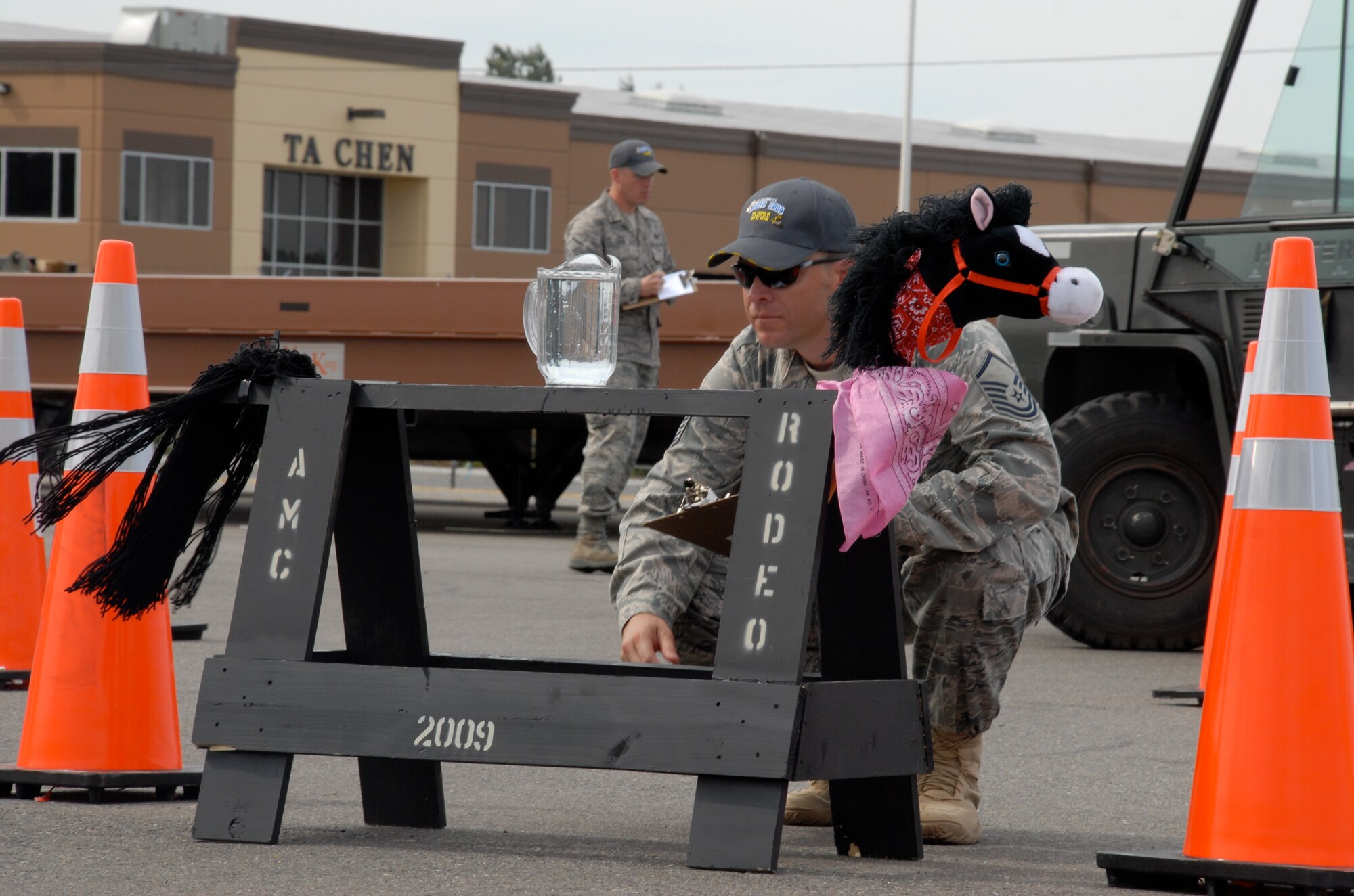 MCCHORD AIR FORCE BASE, Wash. – An Air Mobility Command aerial porter umpire inspects a pitcher of water which Senior Airman Andrew Cramer, 732th Air Mobility Squadron, Elmendorf Air Force Base, Alaska, had to avoid spilling during the 10,000-ton forklift driving course event at the Air Mobility Rodeo 2009 July 20. The Rodeo takes place July 19-25 here. Airman Cramer is part of the 515th Air Mobility Operatons Wing team from Hickam AFB, which will compete against 22 other aerial port teams. Events include C-130 engine running on and off load, joint inspection with hazmat, in-transit visibility, 60,000-ton driving course, and a 10,000-ton forklift driving course. (U.S. Air Force photo/Staff Sgt. Carolyn Viss)