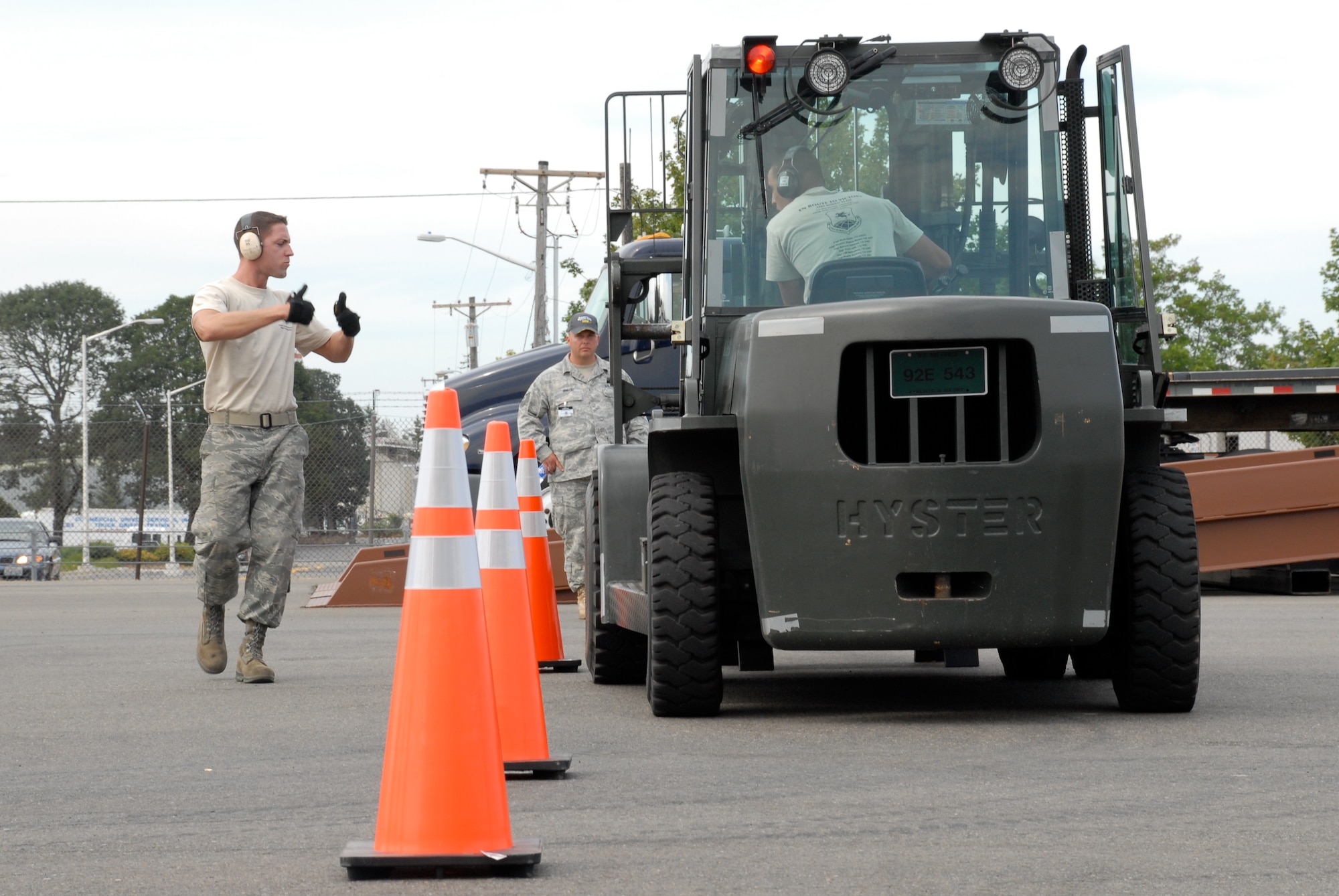 MCCHORD AIR FORCE BASE, Wash. – Staff Sgt. Clifton Robertson, 735th Air Mobility Squadron, Hickam Air Force Base, Hawaii, directs Senior Airman Andrew Cramer, 732th Air Mobility Squadron, Elmendorf Air Force Base, Alaska, as he drives a 10,000-ton forklift through a serpentine course on the flightline in front of an inspector during the Air Mobility Rodeo 2009 here July 20. Both Airmen are part of the 515th Air Mobility Operatons Wing team from Hickam AFB, which will compete against 22 other aerial port teams. Events include C-130 engine running on and off load, joint inspection with hazmat, in-transit visibility, 60,000-ton driving course, and a 10,000-ton forklift driving course. (U.S. Air Force photo/Staff Sgt. Carolyn Viss)