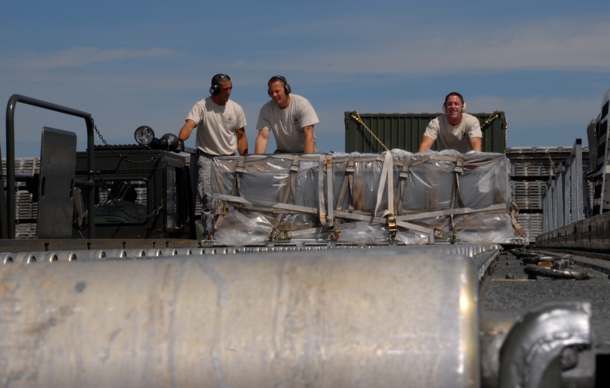 MCCHORD AIR FORCE BASE, Wash. – (From left to right): Senior Airman Andrew Cramer, 732th Air Mobility Squadron, Elmendorf Air Force Base, Alaska; Staff Sgt. Travis Wilt, 733rd Air Mobility Squadron, Kadena Air Base, Japan; and Staff Sgt. Clifton Robertson, 735th Air Mobility Squadron, Hickam Air Force Base, Hawaii, off-load 60,000 tons of cargo from the flightline here during the Air Mobility Rodeo 2009 July 20. The Rodeo takes place here July 19-25. All three Airmen are part of the 515th Air Mobility Operatons Wing team from Hickam AFB, which will compete against 22 other aerial port teams. Events include C-130 engine running on and off load, joint inspection with hazmat, in-transit visibility, 60,000-ton driving course, and a 10,000-ton forklift driving course. (U.S. Air Force photo/Staff Sgt. Carolyn Viss)