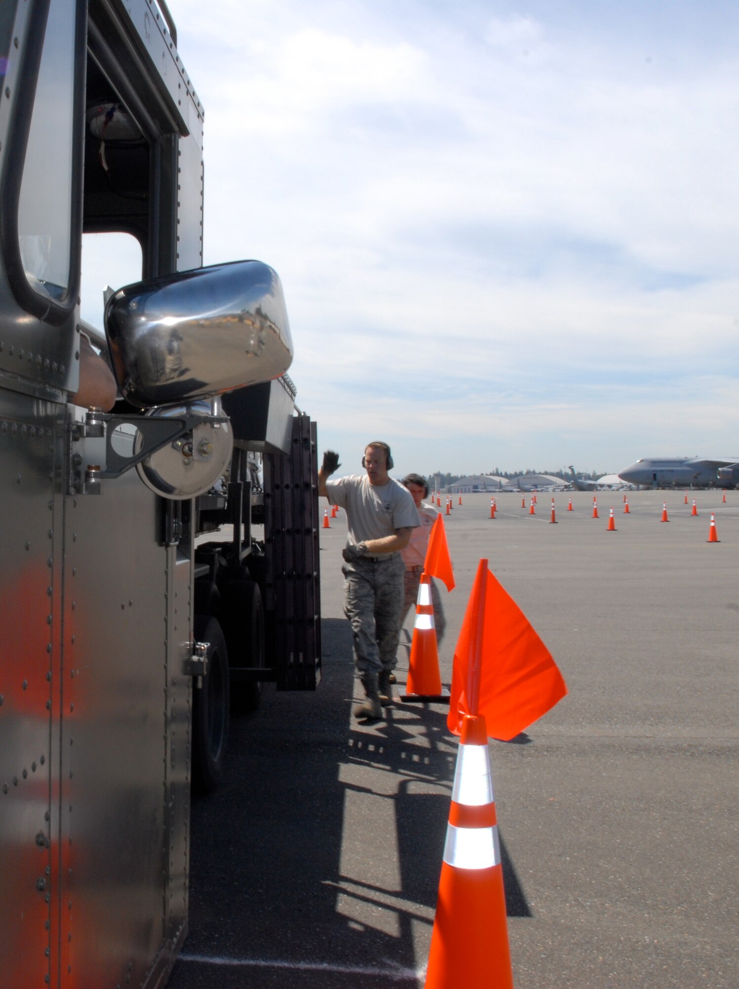 MCCHORD AIR FORCE BASE, Wash. – Staff Sgt. Travis Wilt, 733rd Air Mobility Squadron, Kadena Air Base, Japan, and Staff Sgt. Dustin Barboza, 734th Air Mobility Squadron, Andersen Air Base, Guam, direct Senior Airman Baltazar Valdez as he drives a 60,000-ton on/offload vehicle on the flightline here July 20. Airman Valdez is from the 731st Air Mobility Squadron, Osan Air Base, Korea. A team of eight aerial porters from around the Pacific teamed up for training at Hickam Air Force Base, Hawaii, before the Air Mobility Rodeo 2009, July 19-25, at McChord AFB. (U.S. Air Force photo/Staff Sgt. Carolyn Viss)