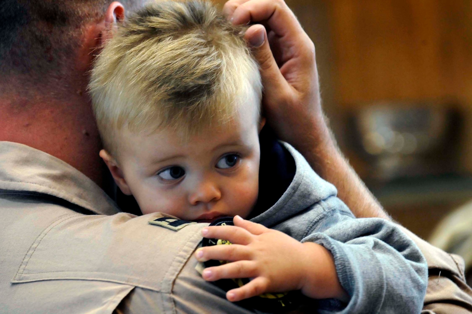 A weapons systems officer assigned to the 37th Bomb Squadron holds his son before deploying July 21. Airmen representing various specialties deployed in support of operations at the 379th Air Expeditionary Wing in Southwest Asia. (U.S. Air Force photo by Airman 1st Class Corey Hook)