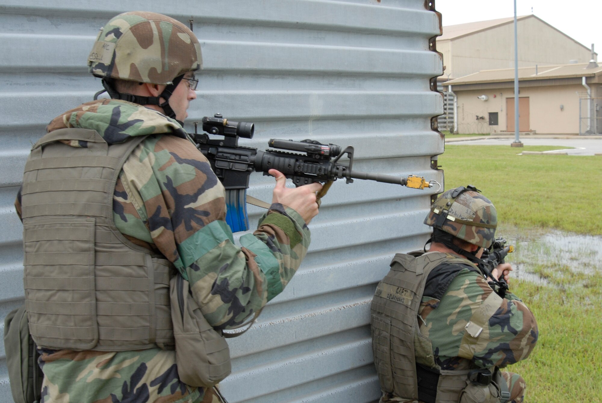 Airman 1st Class Joshua Russell and Capt. Andrew Zelechoski, both assigned to the 8th Security Forces Squadron, maintain a defensive position behind a wall while responding to a simulated ground attack to the control tower July 21, at Kunsan Air Base, Republic of Korea. These airmen are participating in a peninsula wide operational readiness exercise. (U.S. Air Force photo/Staff Sgt. Darnell T. Cannady)