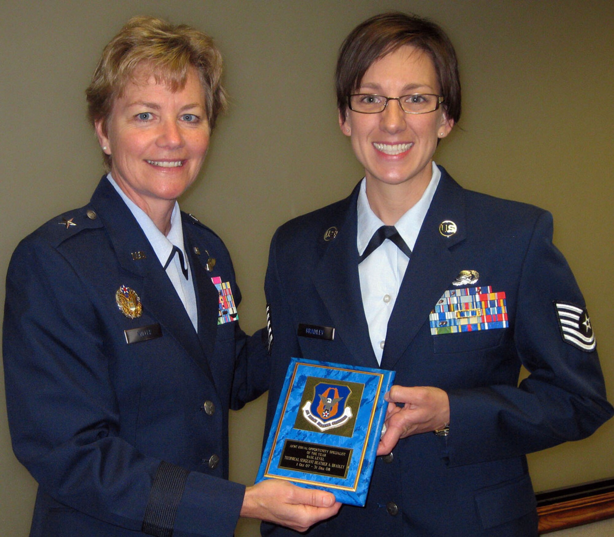TRAVIS AIR FORCE BASE, Calif. -- During the 349th Air Mobility Wing staff meeting July 12, 2009, Brig. Gen. Maryanne Miller (center) presented two Community College of the Air Force degrees. Both Tech. Sgt. Heather Bradley, on the left, and Master Sgt. Teresa Grieff, right, received associates of applied science degrees in Social Services. Sergeant Bradley is assigned to the Equal Opportunity office, and Sergeant Grieff is assigned to the 349th Mission Support Squadron, and is also one of the elite members of the wing Honor Guard. (U.S. Air Force photo/SSgt. Meredith Mingledorff)