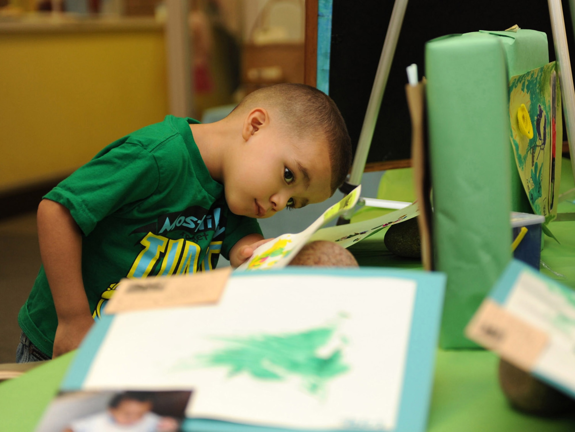 HOLLOMAN AIR FORCE BASE, N.M. -- Alexavier Villanueva, 3, son of Staff Sgt. Javier Villanueva, 49th Maintenance Squadron, looks at another child?s artwork during the Child Development Center Enrichment Center?s Art Fair here July 17. Artwork was broken down by age groups, ranging from six weeks to five years of age, including artwork from parents and CDC staff. (U.S. Air Force photo by Airman 1st Class Sondra M. Escutia)