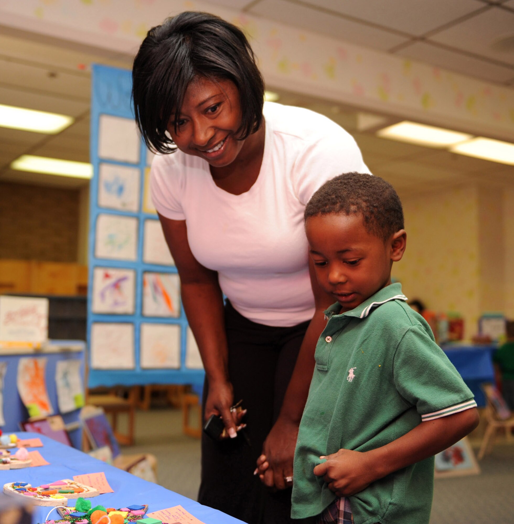 HOLLOMAN AIR FORCE BASE, N.M. -- Caleb Blue, 4, and his mother, Martha Blue, check out the artwork displayed at the Child Development Center Enrichment Center?s Art Fair here July 17. The Art Fair showcased art by children from six months to five years of age. (U.S. Air Force photo by Airman 1st Class Sondra M. Escutia)
