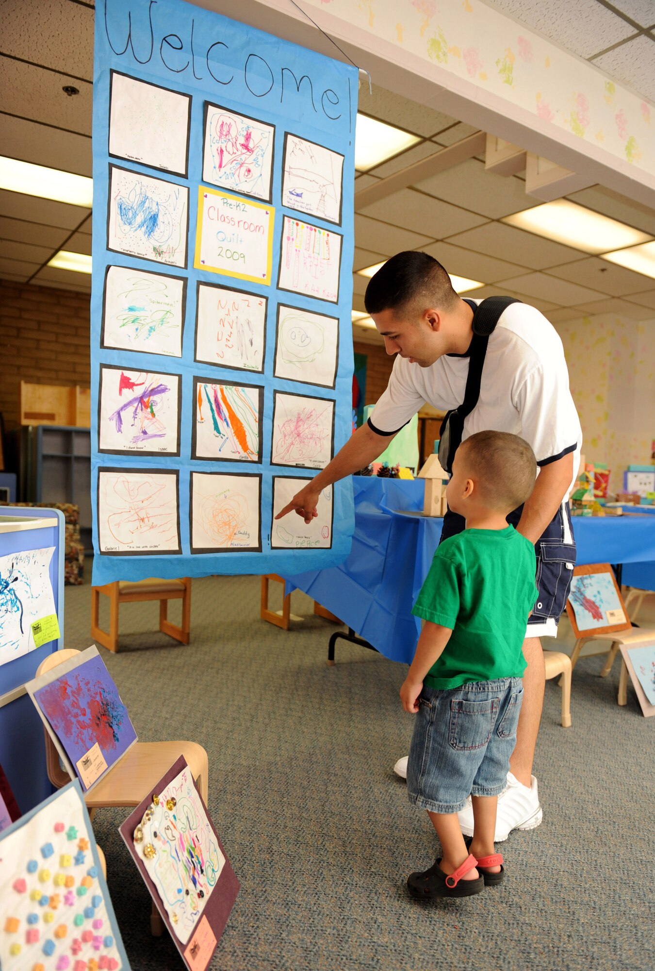 HOLLOMAN AIR FORCE BASE, N.M. -- Alexavier Villanueva, 3, and his father, Staff Sgt. Javier Villanueva, 49th Maintenance Squadron, check out a piece of Alexavier's artwork displayed during the Child Development Center Enrichment Center's Art Fair here July 17. The Art Fair was designed to showcase the creative talent of the children who attend the CDC. (U.S. Air Force photo by Airman 1st Class Sondra M. Escutia)