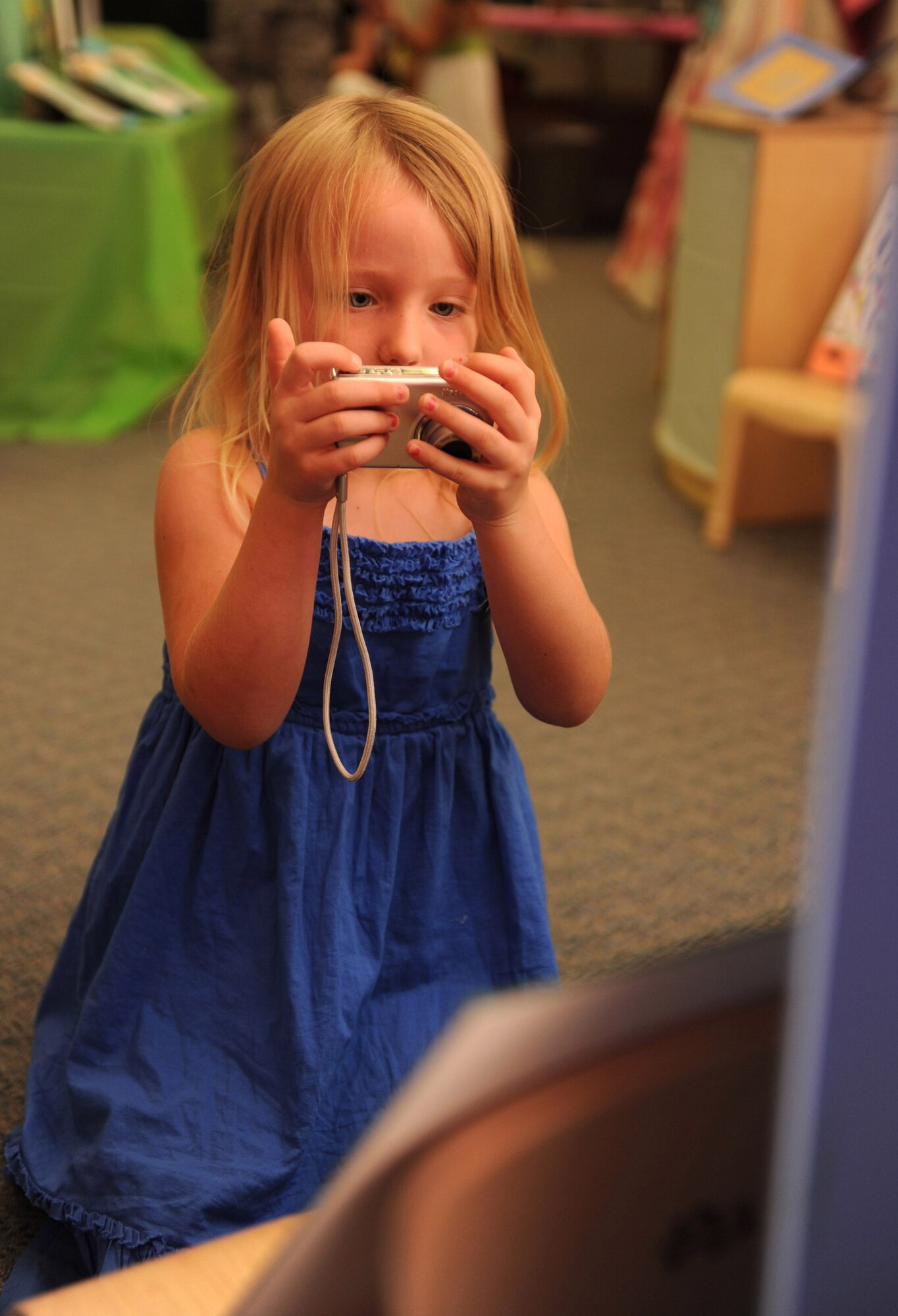 HOLLOMAN AIR FORCE BASE, N.M. -- Riley Mulhollan, 4, tries to take a photograph of a piece of her artwork that was displayed during the Child Development Center Enrichment Center's Art Fair here July 17. The Art Fair was open to all of Team Holloman to view artwork by children, parents and CDC staff. (U.S. Air Force photo by Airman 1st Class Sondra M. Escutia)