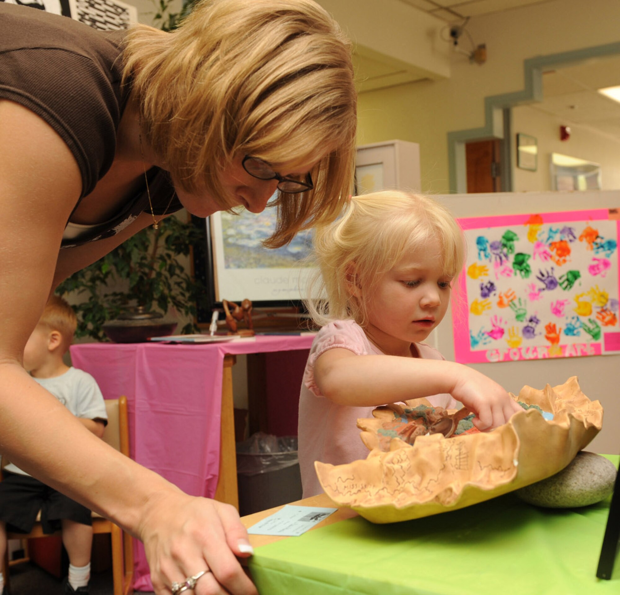 HOLLOMAN AIR FORCE BASE, N.M. -- Felicity Morice, 3, and her mother, Tiffany, look at a piece of artwork submitted by an adult during the Child Development Center Enrichment Center?s Art Fair here July 17. The Art Fair showcased art by children from six weeks to five years of age. (U.S. Air Force photo by Airman 1st Class Sondra M. Escutia)