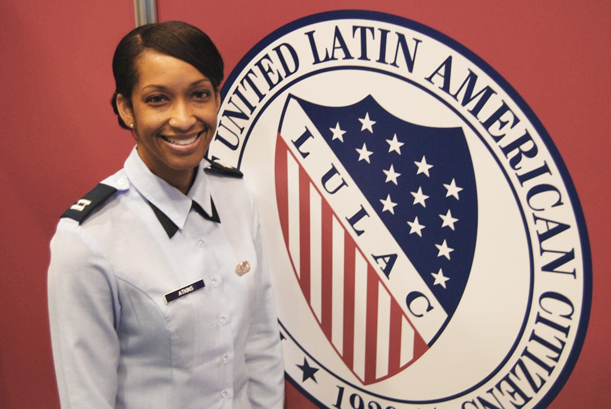 Capt. Joy Atkins stands at the League of United Latin American Citizens logo July 17 at the LULAC convention and exposition in San Juan, Puerto Rico. LULAC is the oldest Hispanic civil rights organization in the U.S. Captain Atkins is a Human Resources Development Council member assigned to the 459th Air Refueling Wing at Andrews Air Force Base, Md. (U.S. Air Force photo/Tech. Sgt. Amaani Lyle)