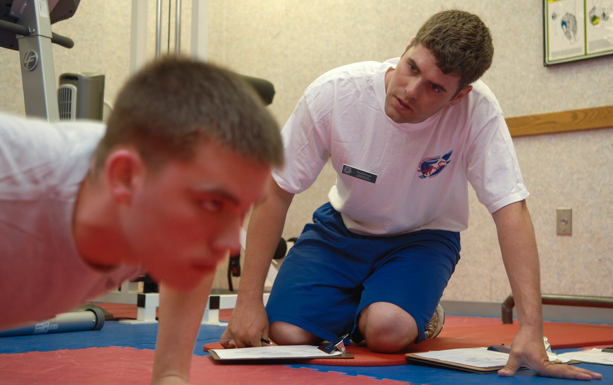 ELMENDORF AIR FORCE BASE, Alaska -- Patrick Lais observes the pushups of a tester during a PT evaluation July 17. The Health and Wellness Center have begun employing civilian and contracted members to take over the centralized PT testing. Lais is a fitness test cell specialist with the HAWC. (U.S. Air Force photo/Senior Airman David Carbajal)