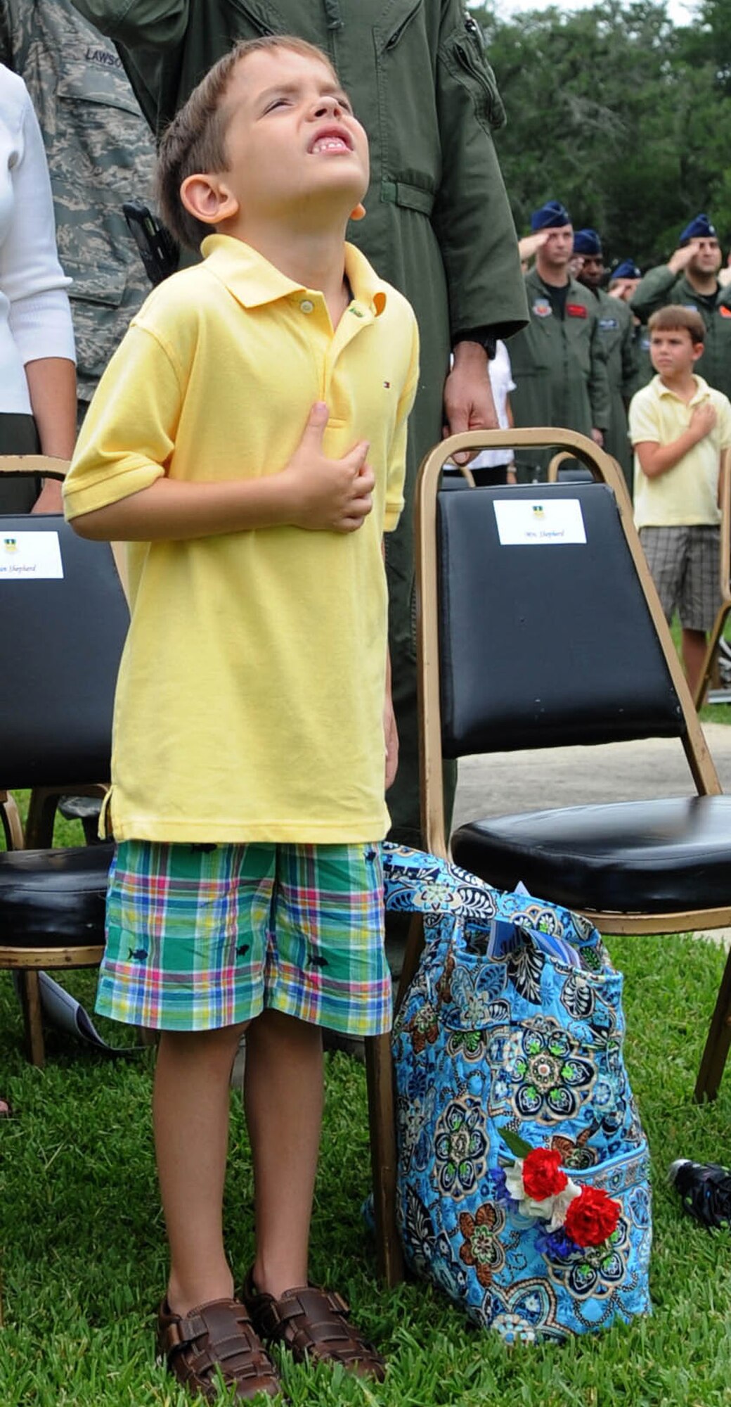 Noah, son of 1st Lt. Joshua Shepherd, places his hand over his heart during the playing of the national anthem as the flag is raised at the 2nd Bomb Wing flag pole July 21 during the RAIDR 21 Remembrance Ceremony. More than 200 Airmen, friends and family members attended the ceremony to remember the six fallen aircrew members who died in a crash July 21, 2008, while deployed to Andersen AFB, Guam.  Lieutenant Shepherd was one of the crew members of the B-52 Stratofortress, call sign RAIDR 21. (U.S. Air Force photo/Senior Airman Alexandra Longfellow)