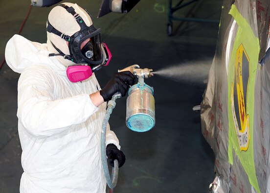 Senior Airman Jonathon Shanley, 4th Equipment Maintenance Squadron aircraft structural maintenance journeyman, covers the 4th Fighter Wing patch with a clear protective coat, one of the finishing touches before a jet is sent back to the flight line on Seymour Johnson Air Force Base, N.C. July 14, 2009. It takes the Airmen in the paint barn 5 duty days to sand, prepare, mask, paint and re-mark a jet like the ones on the flight line. (U.S. Air Force photo by Airman 1st Class Rae Perry)