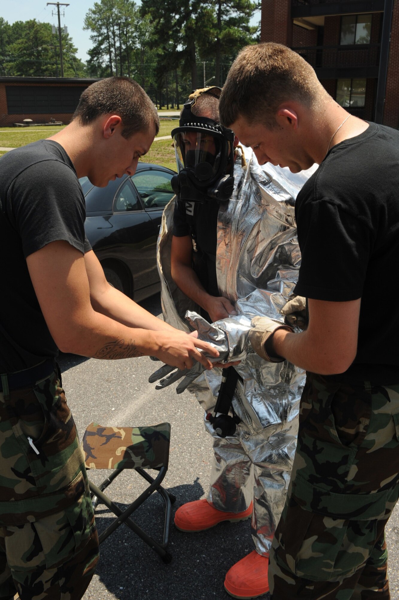 Airmen 1st Class Landon Smith and Christopher Sangle, help Airman 1st Class Dustin Beckley, suit up for an all hazards response training exercise at Seymour Johnson AFB, N.C., July 15, 2009. Airman Beckley is part of the fire department?s first response team, trained to respond to emergencies. All are 4th Civil Engineer Squadron firefighters. (U.S. Air Force photo by Senior Airman Ciara Wymbs)  