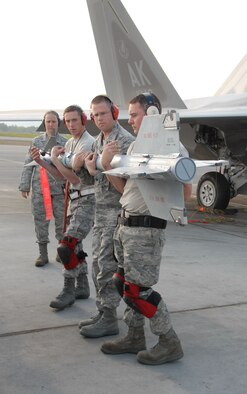 Tech Sgts. Bishop Bailey and Michael Mitchell and Staff Sgt Nick Barnes from the 477th Fighter Group Aircraft Maintenance Squadron carry an AIM-9 to load on an F-22A Raptor during the 3rd Wing?s Load Crew Competition held on July 10.  They pitted their skills against teams from the 19th AMU, 525th AMU and the 90th AMU.  This was first time a Reserve team from the 477th AMXS took part in the quarterly event.  During the competition four teams competed in several different challenges including a toolbox inspection, uniform inspection, knowledge test and weapons load challenge.  During the weapons load challenge, the 477th AMXS team loaded weapons on the F-22 with incredible speed ? completing the load in a time of 33:26. (Air Force Photo / Maj. Cary McPartlin)