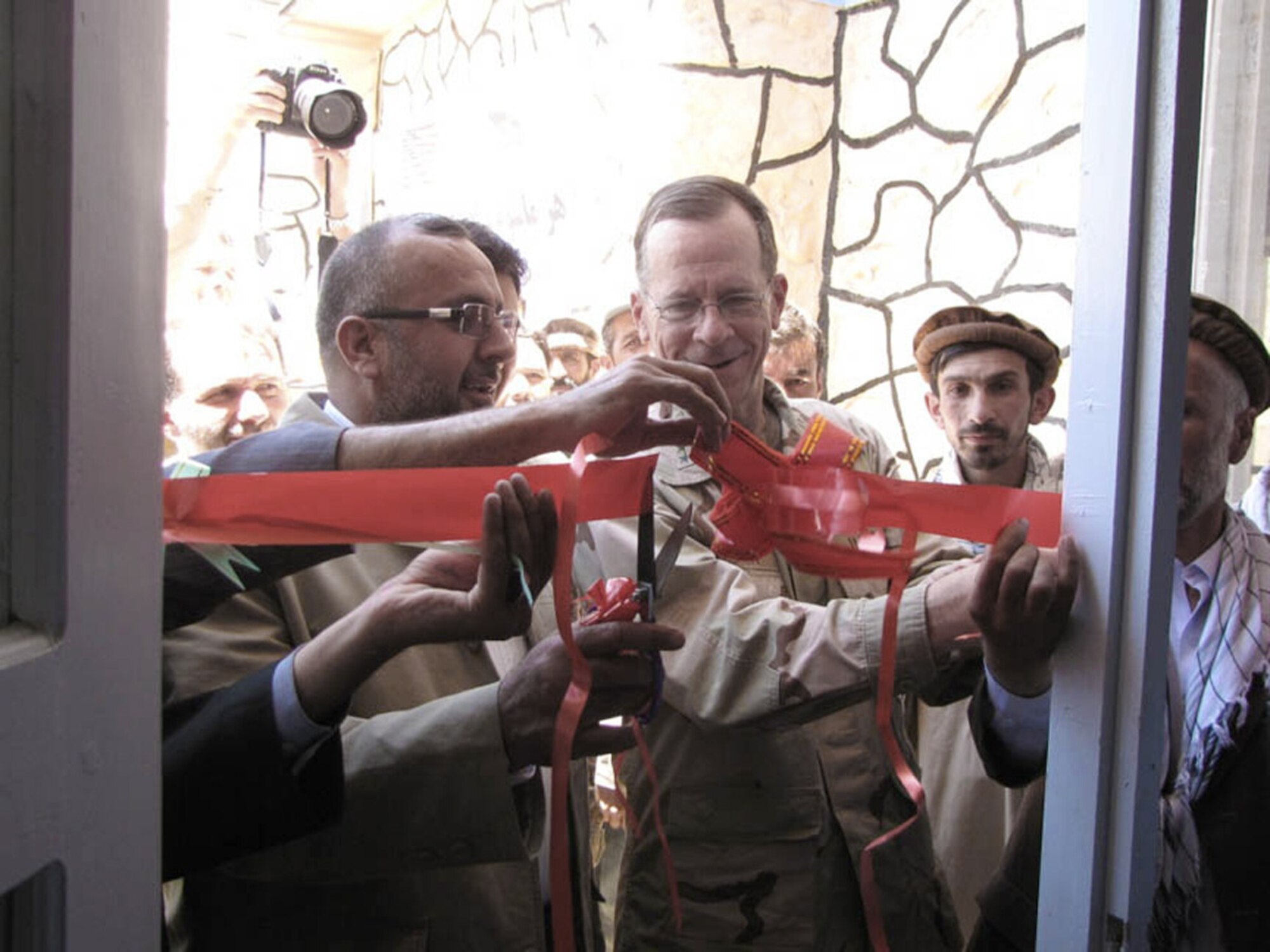 Panjshir Governor Haji Bahlol (left) and Navy Adm. Mike Mullen, chairman of the Joint Chiefs of Staff, cut the ceremonial ribbon July 15 at the entrance to the new Peshgur School for Girls in the Khenj district of eastern Afghanistan's Panjshir province.  (U.S. Air Force photo/Capt. Stacie N. Shafran)