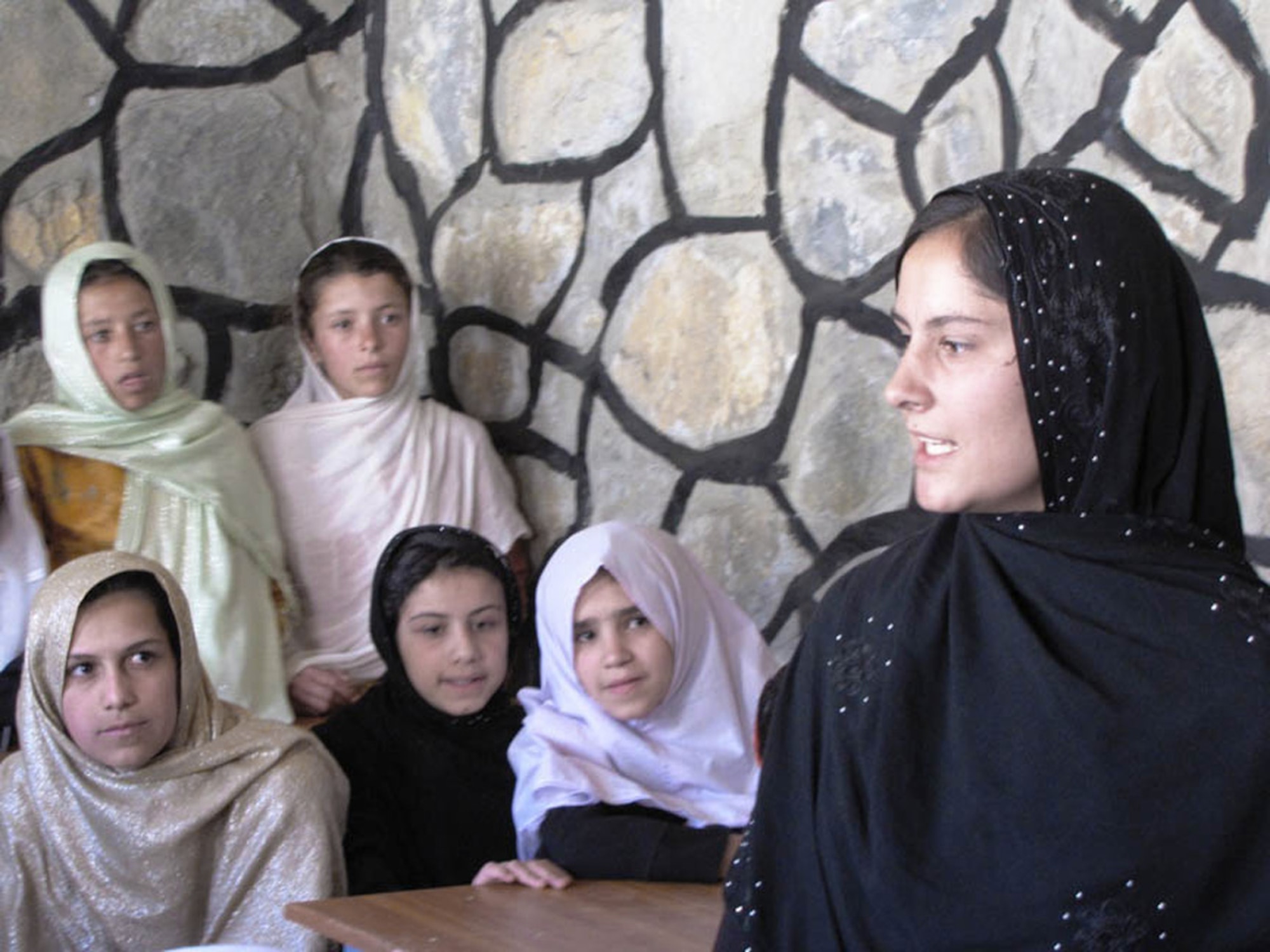 Lima, 16, a 12th grader at a Kabul high school, translates English into Dari for local Afghans as Navy Adm. Mike Mullen, chairman of the Joint Chiefs of Staff, speaks July 15 during the opening ceremony of the Peshgur School for Girls in the Khenj district of eastern Afghanistan's Panjshir province. During the ceremony, Lima also spoke with the students about her educational path.  Fluent in Dari, Pashto, English and Urdu, she is currently preparing for her college entrance exams, and plans to study medicine at Kabul University.  (U.S. Air Force photo/Capt. Stacie N. Shafran) 