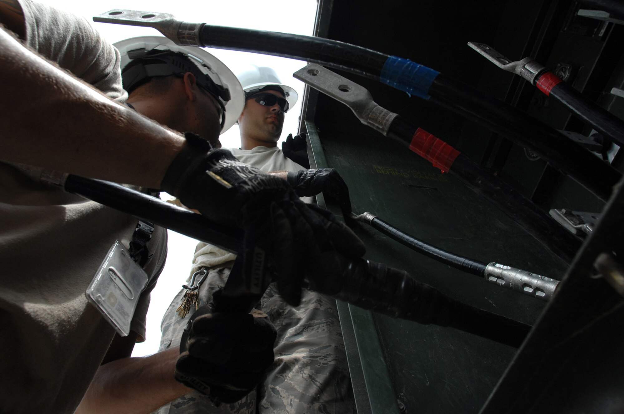 WHITEMAN AIR FORCE BASE, Mo. - Senior Airmen Aaron Burgan and Daniel Colantino, 509th Civil Engineer Squadron, work together to replace a transformer after an un-replaceable fuse had blown, July 21. Both Airmen Burgan and Colantion were called late at night while on standby status and worked around the clock to ensure the transformer was properly replaced. (U.S. Air Force photo/Senior Airman Kenny Holston)