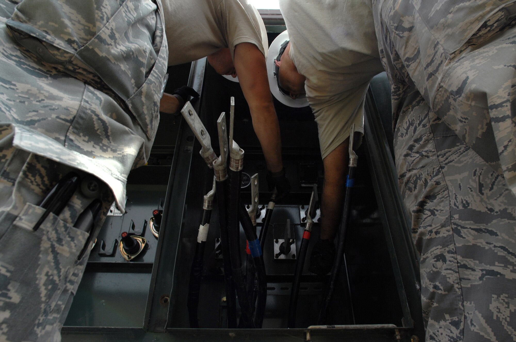 WHITEMAN AIR FORCE BASE, Mo. - Senior Airman Aaron Burgan, and Daniel Colantino, 509th Civil Engineer Squadron, work together to replace a transformer after an un-replaceable fuse had blown, July 21. Both Airmen Burgan and Colantino were called late at night while on standby status and worked around the clock to ensure the transformer was properly replaced. (U.S. Air Force photo/Senior Airman Kenny Holston)