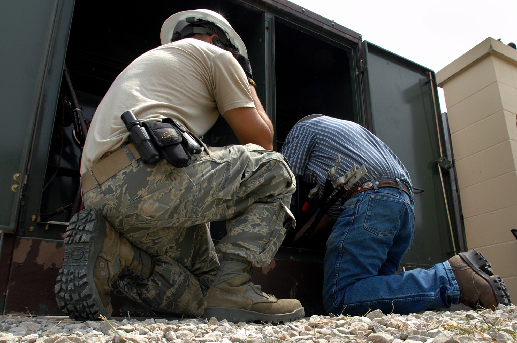 WHITEMAN AIR FORCE BASE, Mo. - Senior Airman Aaron Burgan and Civilian Contractor Mr. Ken Newby, 509th Civil Engineer Squadron, work together to replace a transformer after an un-replaceable fuse had blown, July 21. The transformer was later replaced and power to the surrounding buildings was restored. (U.S. Air Force photo by Senior Airman Kenny Holston)