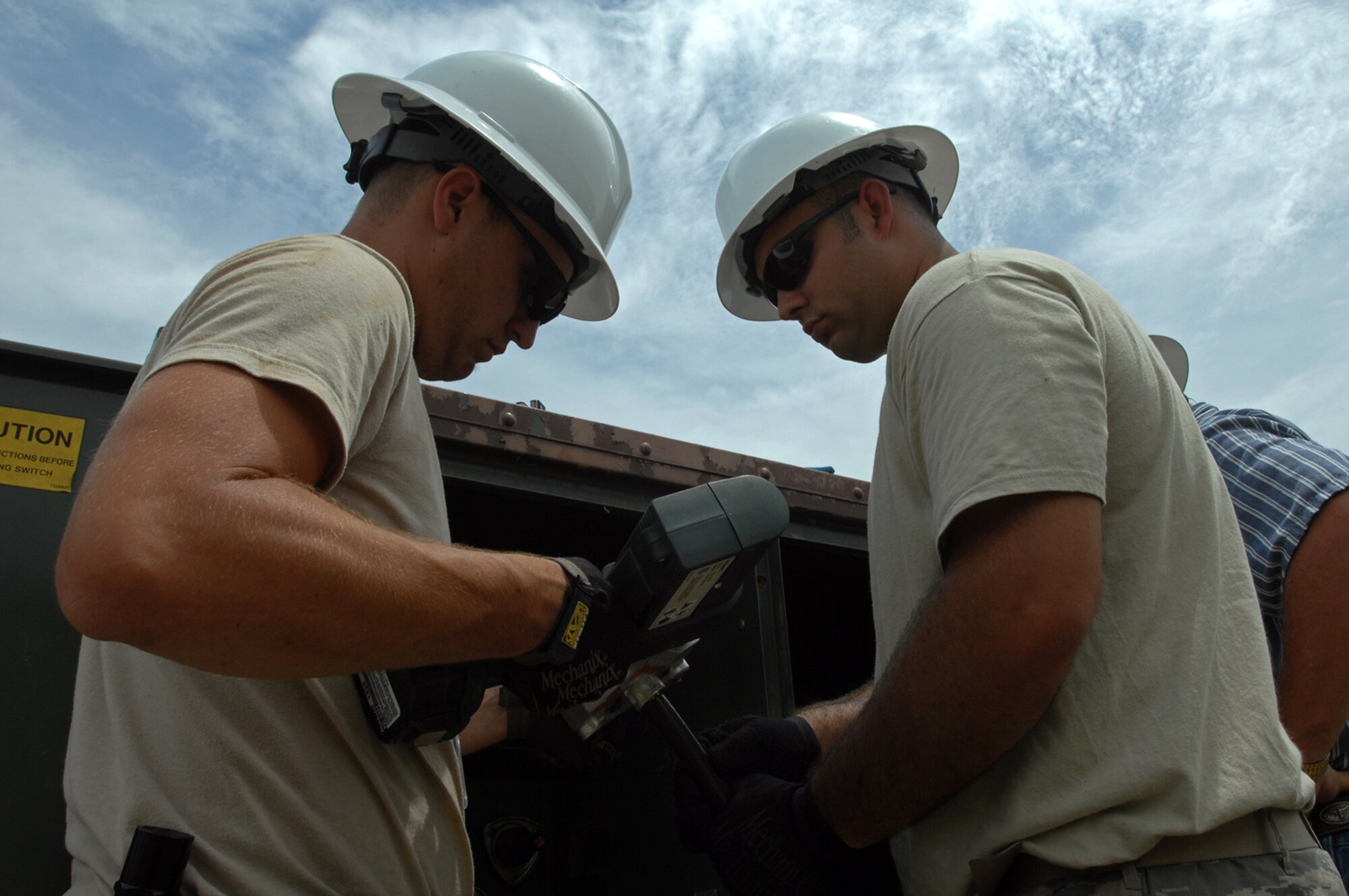 WHITEMAN AIR FORCE BASE, Mo. - Senior Airman Aaron Burgan, and Daniel Colantino, 509th Civil Engineer Squadron, work together to replace a transformer after an un-replaceable fuse had blown, July 21. Both Airmen Burgan and Colantino were called late at night while on standby status and worked around the clock to ensure the transformer was properly replaced. (U.S. Air Force photo/Senior Airman Kenny Holston)