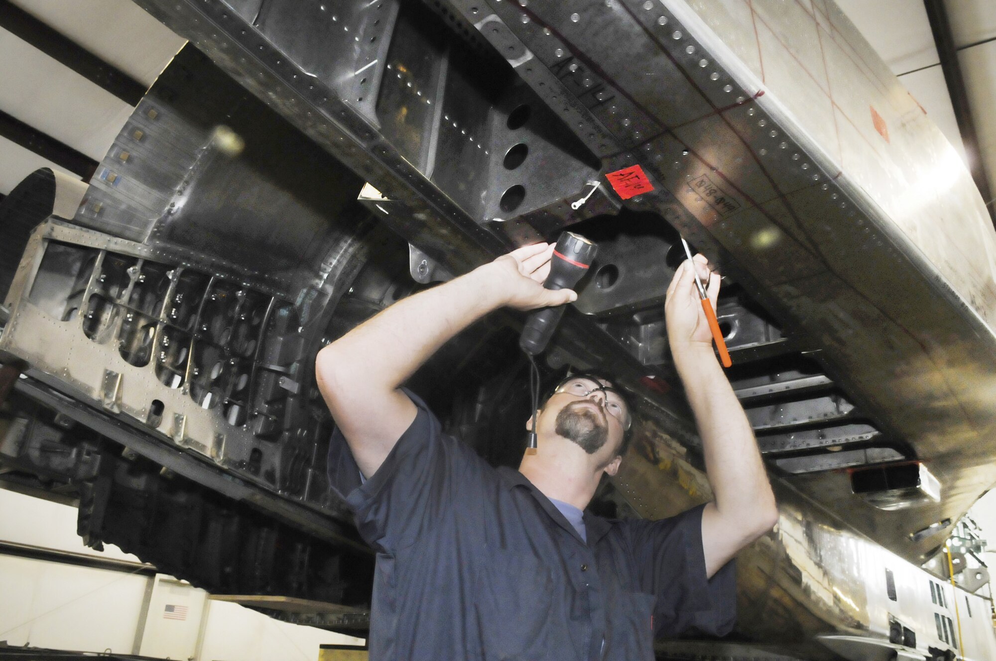 Steve Hartley, site manager for S&K Technologies in Byron, Ga., near Robins Air Force Base, Ga.,  examines the underbelly of an F-15 Eagle prior to disassembly. The crew is tearing down the aging fighter to see how well it is holding up.  (U.S. Air Force photo/Sue Sapp) 
