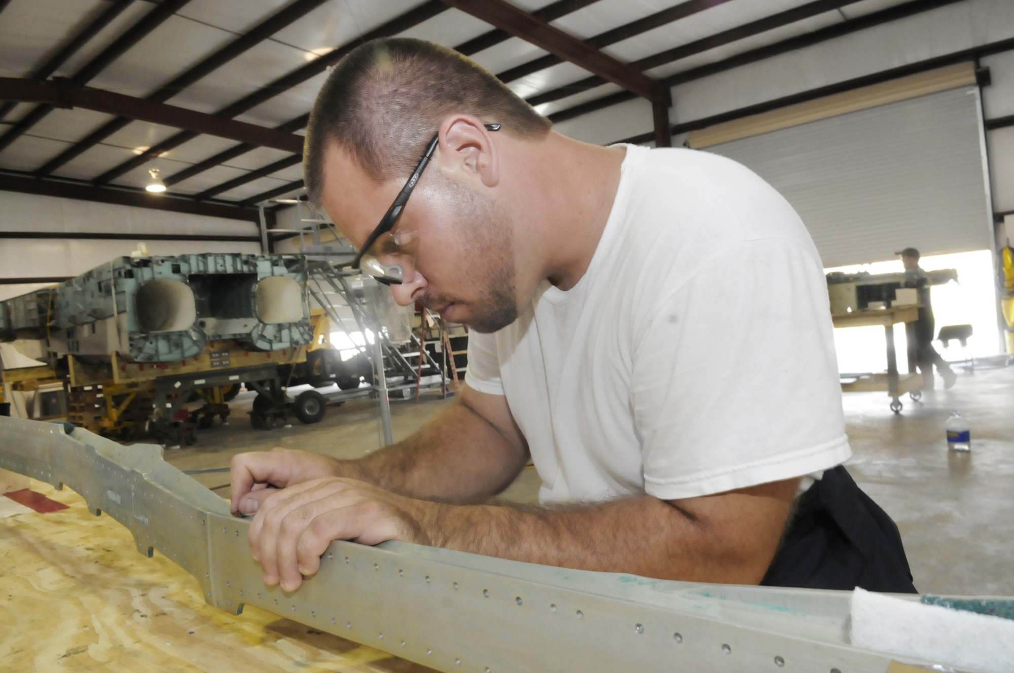 Ben Rogers, with S&K Technologies in Byron, Ga., near Robins Air Force Base, Ga., strips paint and primer off an F-15 Eagle longeron so it can be sent off for analysis. Mr. Rogers is part of a crew that is disassembling an F-15 in an effort to provide maintenance crews more information about the aircraft.  (U.S. Air Force photo/Sue Sapp)