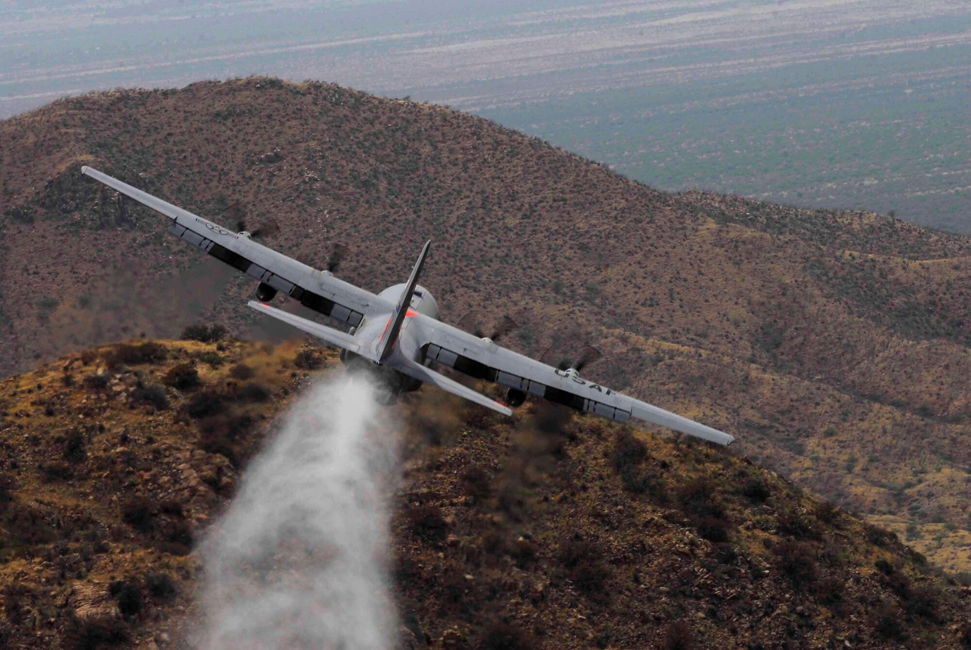 Tucson, Ariz. (May 6, 2009) ? C-130 Aircraft flown by the 145th Airlift Wing, an Air National Guard unit from Charlotte, NC maneuvers close while contour flying to drop a load of simulated retardant during Modular Aerial Fire Fighting training May 3-9 in the Coronado National Forest of Southeastern Arizona. The 145th AW is a contingent of the 302nd Air Expeditionary Group, part of a unified military support effort of U.S. Northern Command to provide assistance to the U.S. Forest Service, state and local agencies, and the National Interagency Fire Center in battling large, uncontrolled wildfires throughout the nation.  The 145th AW is performing upgrade and initial training of aircrews, maintenance crews, and aviation resource management staff as they and three other Airlift Wings from Colorado, California and Wyoming qualify for MAFFS operations in Annual training exercises this week. (Photo by MSgt Dan Beaudreau)