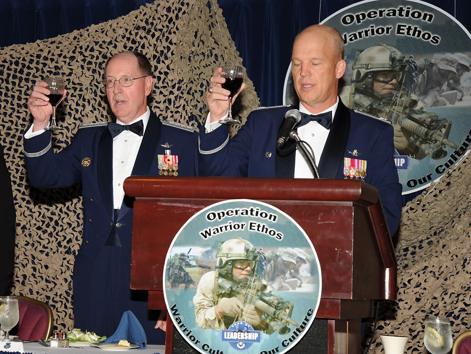 Left to right Gen. C. Robert Kehler, commander Air Force Space Command, and Col. Jay Raymond, 21st Space Wing commander, charge their glasses for a toast during the “Operation Warrior Ethos” Dining Out July 17. The event, sponsored by the Rocky Mountain Company Grade Officer Council, was a unique fusion of formal trappings and combat-themed elements, and was Peterson’s culminating event for the Air Force Space Command Year of Leadership, which focused on warrior ethos during the month of July. About 500 Airmen, Soldiers, and Canadian servicemembers attended the event. (Air Force photo by Roberta McDonald)