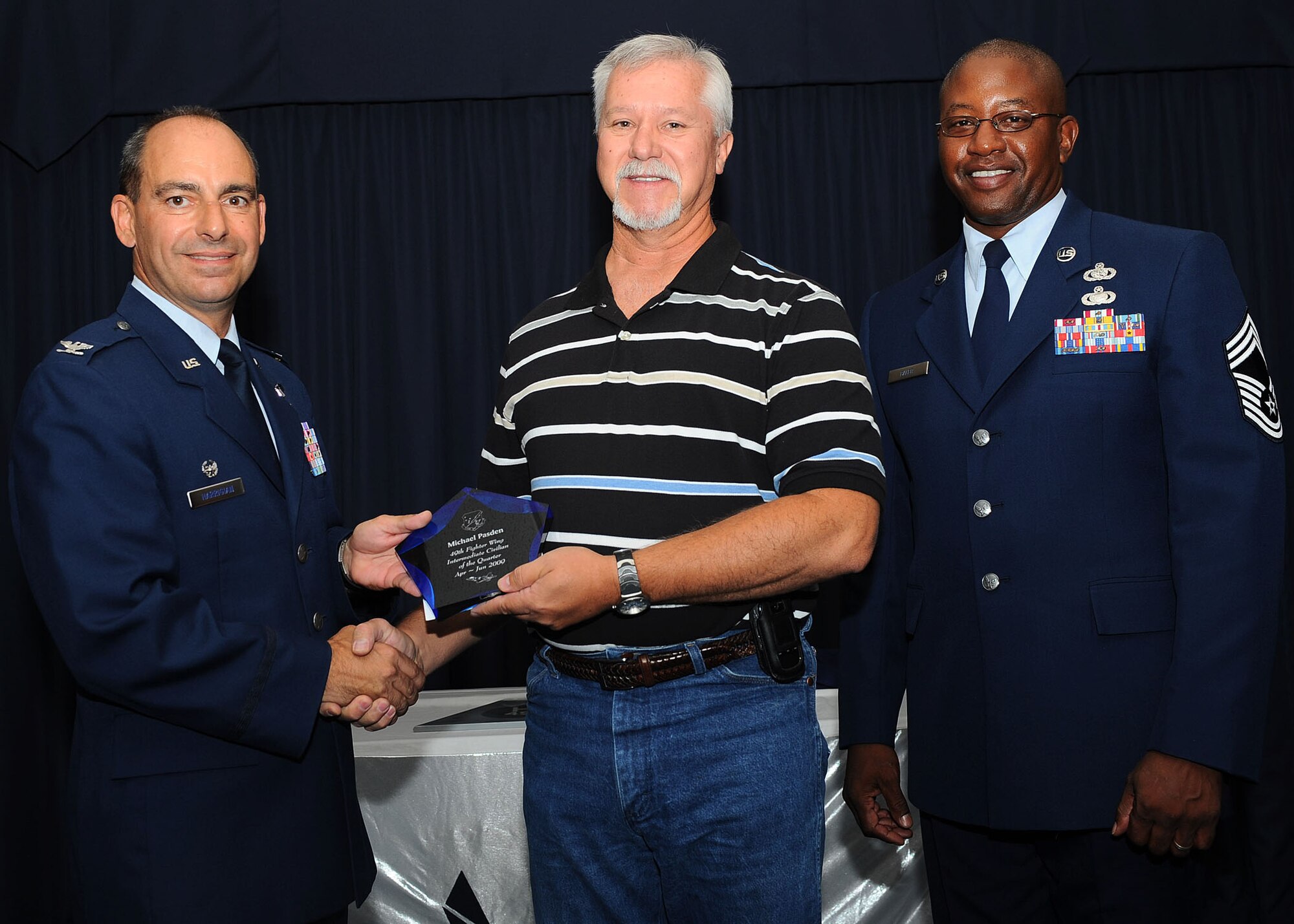 Col. Jeff Harrigian, 49th Fighter Wing commander, and Chief Master Sgt. Jerome Baker, 49th Mission Support Group, present the award for Wing intermediate civilian of the quarter to Mr. Michael Pasden, 49th Civil Engineer Squadron, at Holloman Air Force Base, N.M., July 16.  The 49th Fighter Wing Quarterly Awards recognized the hard work of the 2nd quarter winners. 