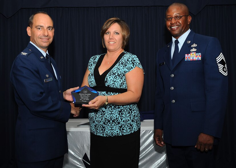 Col. Jeff Harrigian, 49th Fighter Wing commander, and Chief Master Sgt. Jerome Baker, 49th Mission Support Group, present the award for Wing junior civilian of the quarter to Ms. Theresa Granados, 49th Maintenance Operations Squadron, at Holloman Air Force Base, N.M., July 16.  The 49th Fighter Wing Quarterly Awards recognized the hard work of the 2nd quarter winners. 