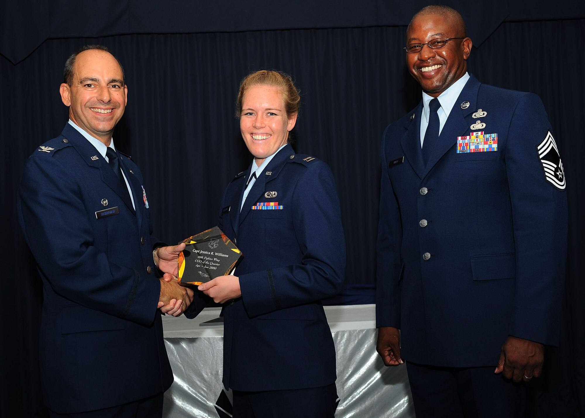 Col. Jeff Harrigian, 49th Fighter Wing commander, and Chief Master Sgt. Jerome Baker, 49th Mission Support Group, present the award for Wing company grade officer of the quarter to Capt. Jessica Williams, 49th Maintenance Support Squadron, at Holloman Air Force Base, N.M., July 16.  The 49th Fighter Wing Quarterly Awards recognized the hard work of the 2nd quarter winners. 