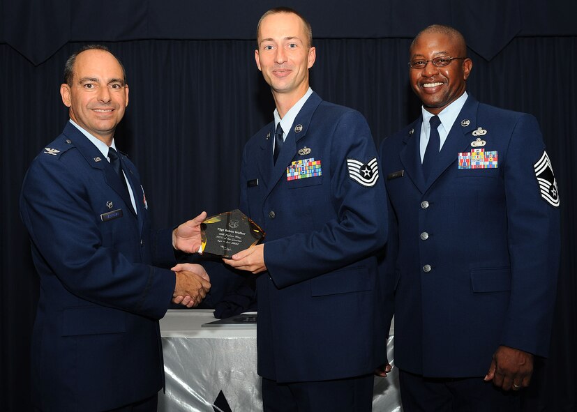 Col. Jeff Harrigian, 49th Fighter Wing commander, and Chief Master Sgt. Jerome Baker, 49th Mission Support Group, present the award for Wing Non-Commissioned Officer of the quarter to Tech. Sgt. Robin Walker, 49th Aircraft Maintenance Support Squadron, at Holloman Air Force Base, N.M., July 16.  The 49th Fighter Wing Quarterly Awards recognized the hard work of the 2nd quarter winners