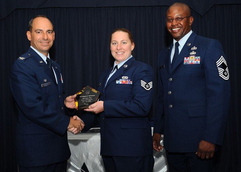 Col. Jeff Harrigian, 49th Fighter Wing commander, and Chief Master Sgt. Jerome Baker, 49th Mission Support Group, present the award for Wing Airman of the quarter to Staff Sgt. Meagan McGovern, 49th Maintenance Support Squadron, at Holloman Air Force Base, N.M., July 16.  The 49th Fighter Wing Quarterly Awards recognized the hard work of the 2nd quarter winners.